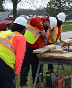 Highway construction students at KCC working with power-drills and lumber.